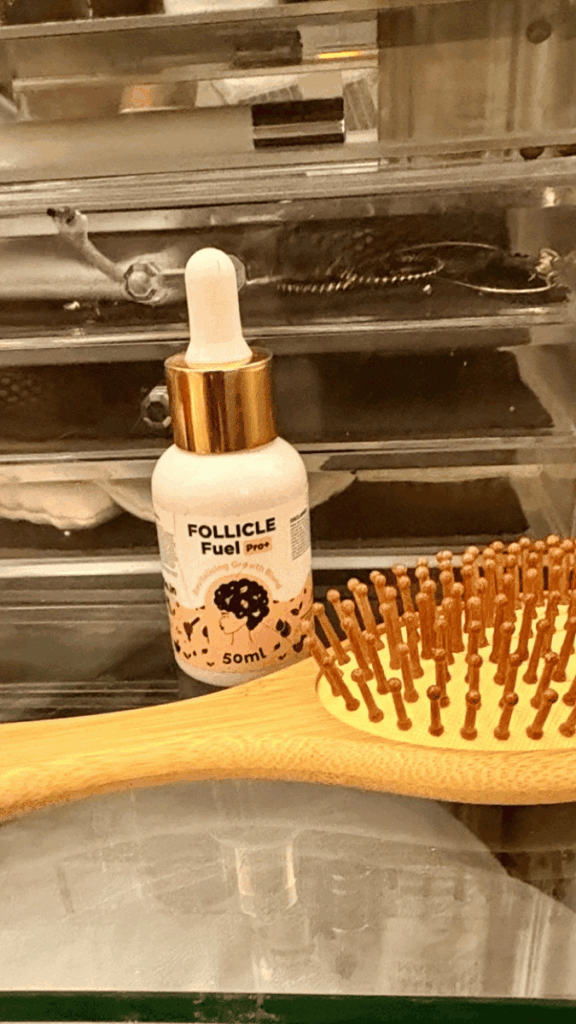Image of a scalp massage brush and hair growth serum used during a nightly scalp care routine.