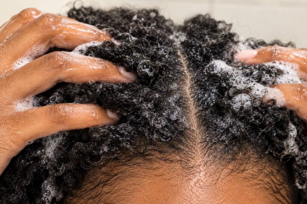 close up of woman's scalp with shampoo on it