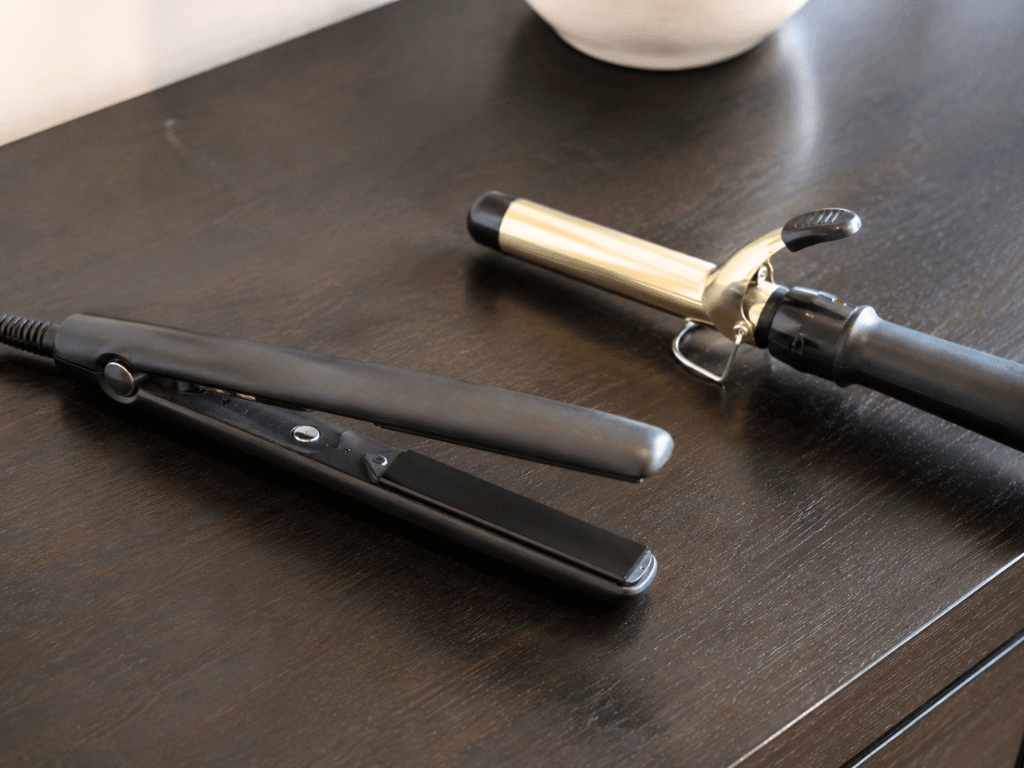 a flat iron and a curling iron on a table