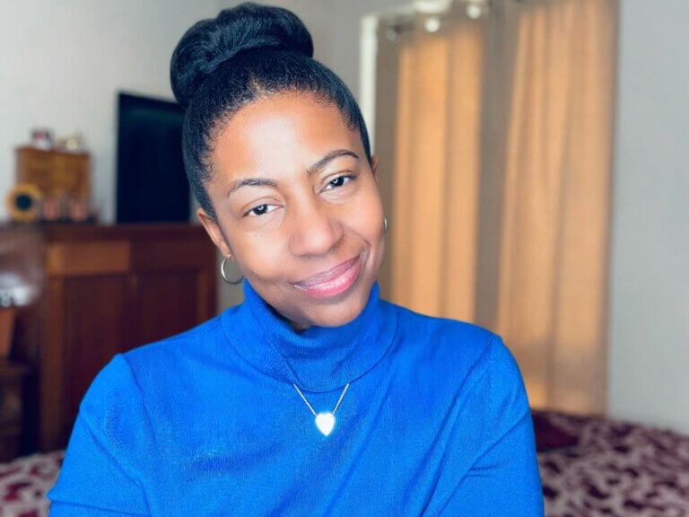 top bun protective style on smiling woman with natural hair