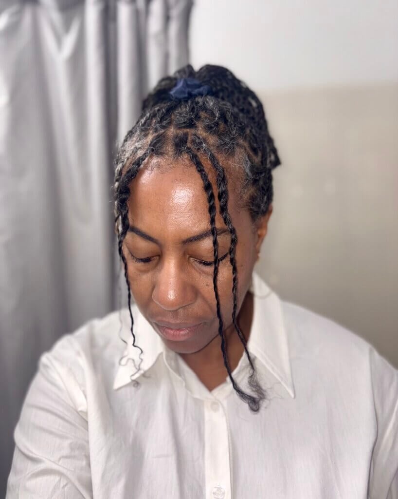 woman with ponytail with mini twists and 2 front loose twists looking down