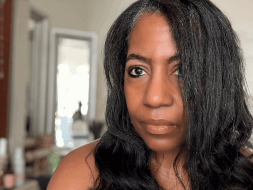 woman with straightened natural hair looking reflectively