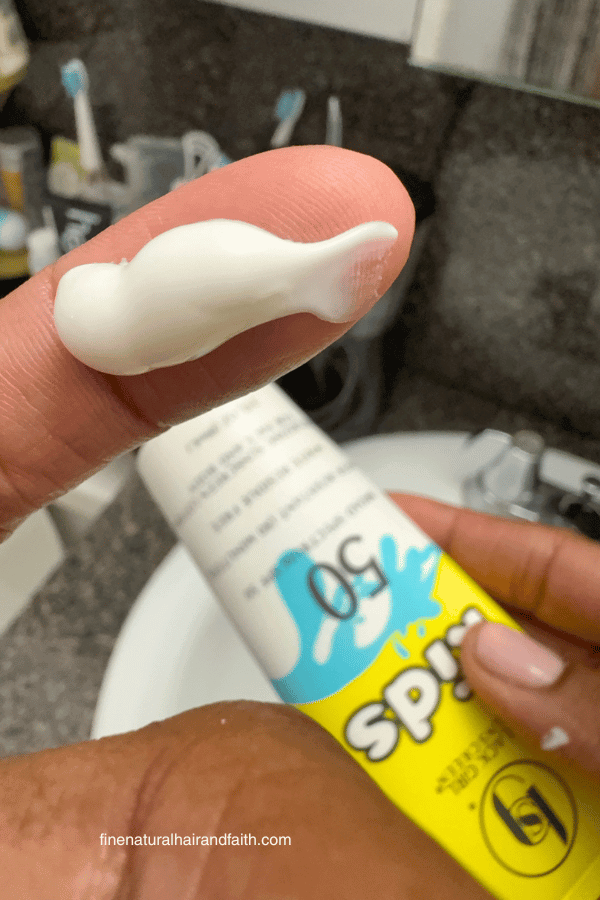 black girl's sunscreen kids spf50 squeezed on to a finger