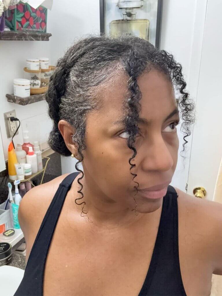 Natural hair updo with two front braids and curly face-framing tendrils