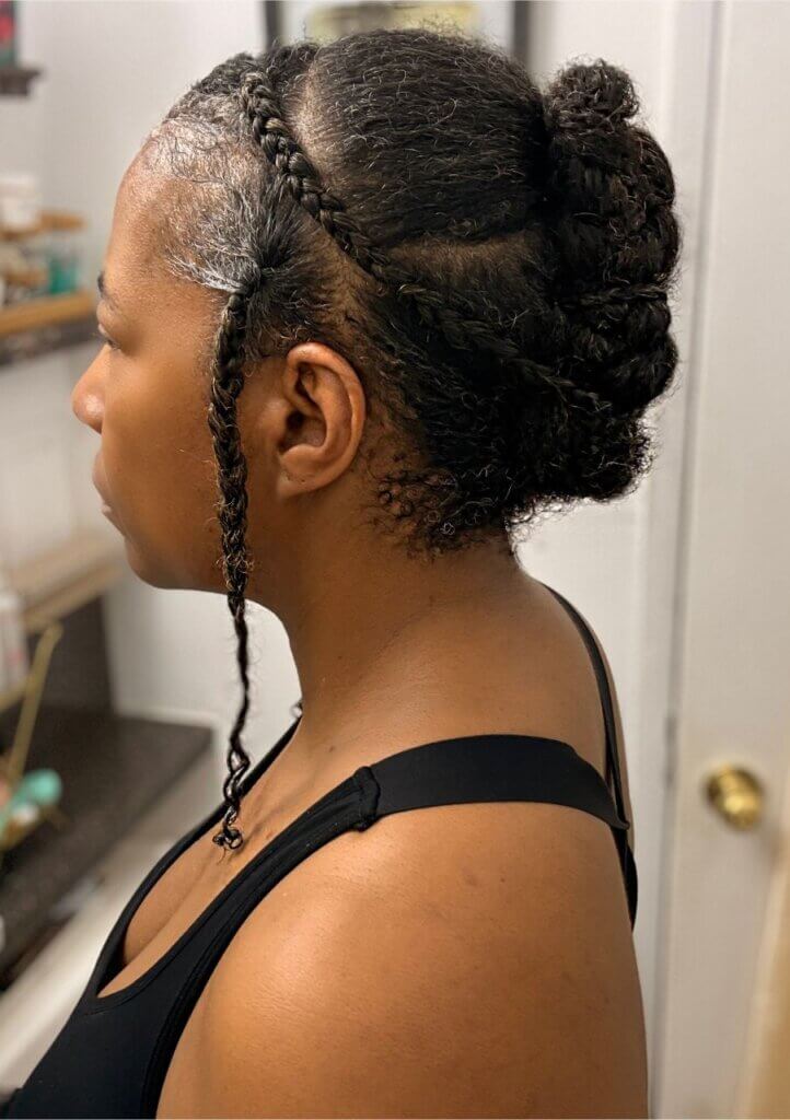Braided natural hairstyle with side braids and hair pinned into a low updo