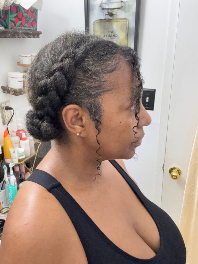 Natural hair updo with braided sides and curly face-framing tendrils