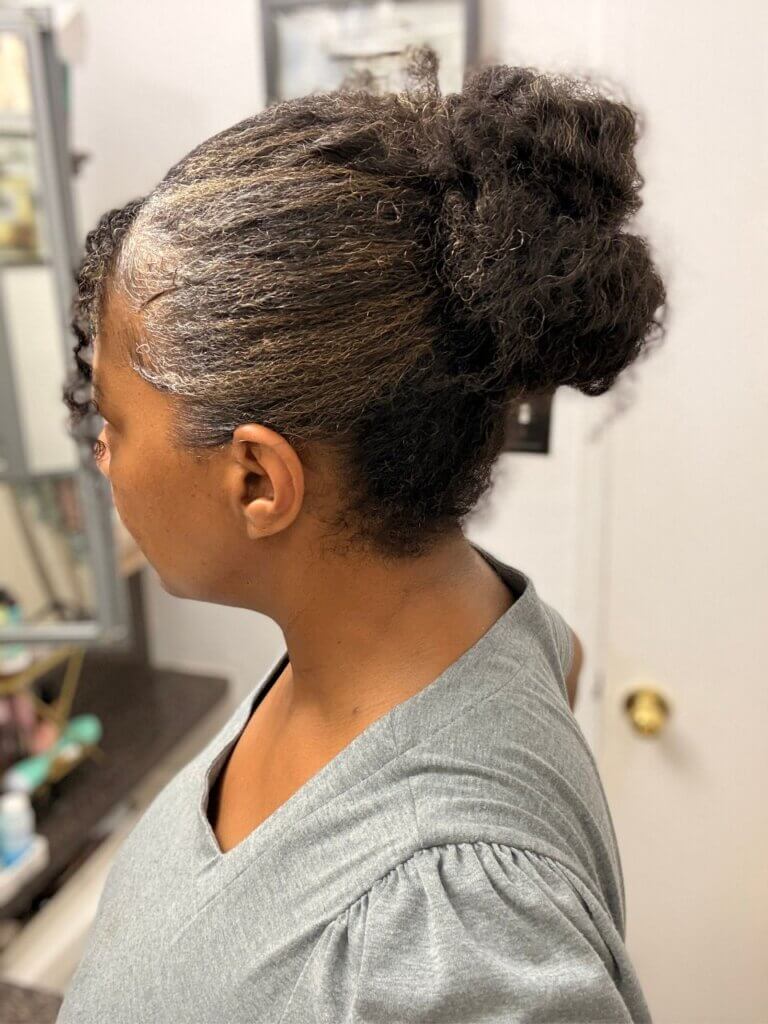 Side view of protective natural hair bun with smooth sides and tucked ends