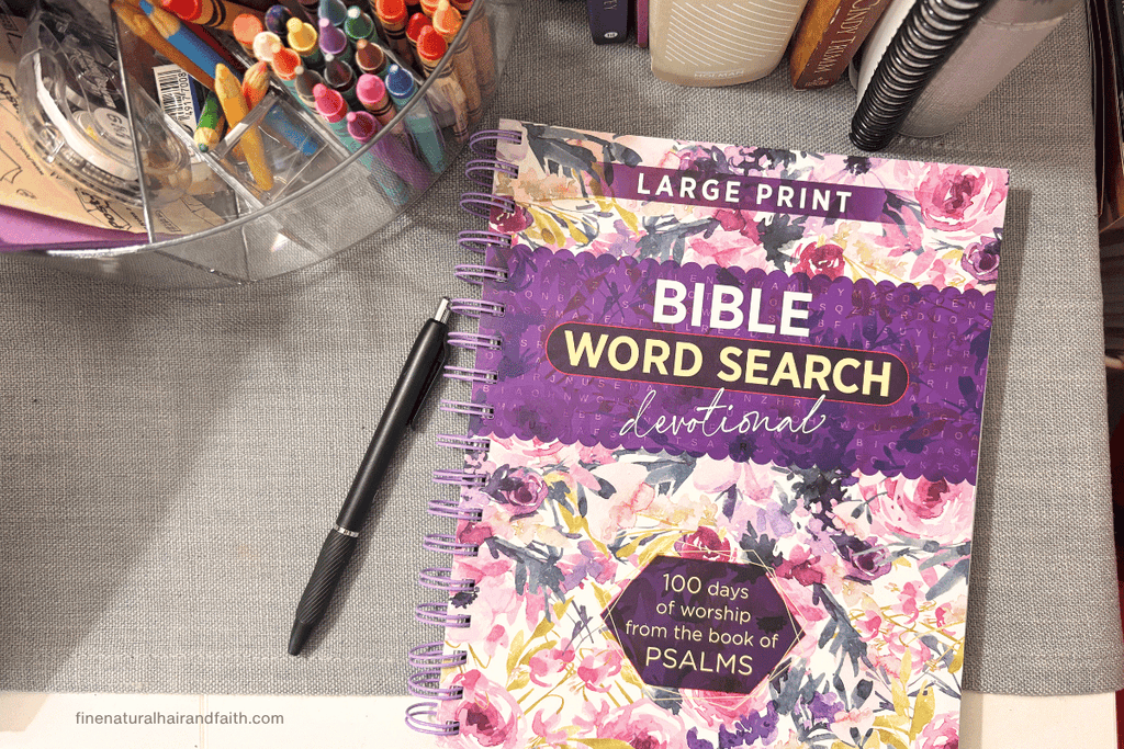 A colorful Bible word search devotional surrounded by pens and markers,