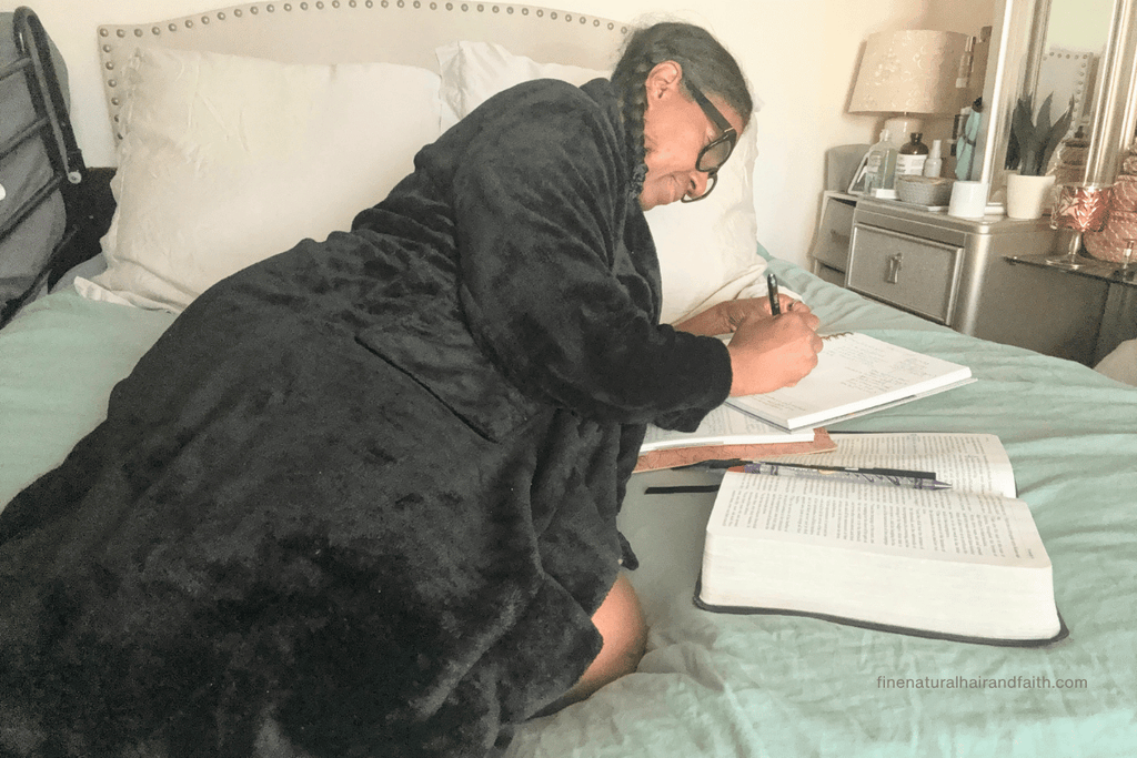 woman doing a deeper Bible study on a bed as a way to observe a sunday sabbath
