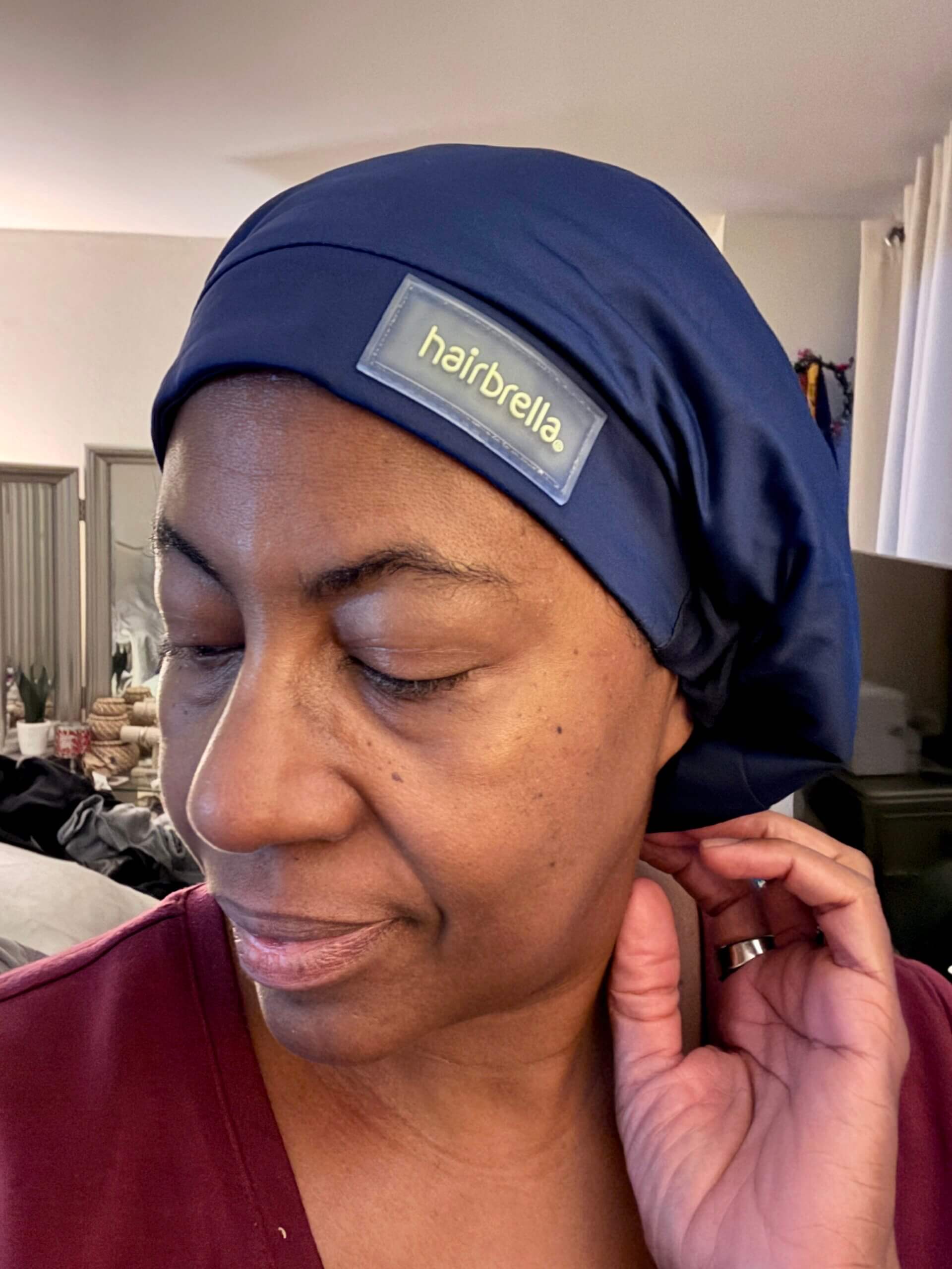 blue Hairbrella waterproof rain hat on a black woman